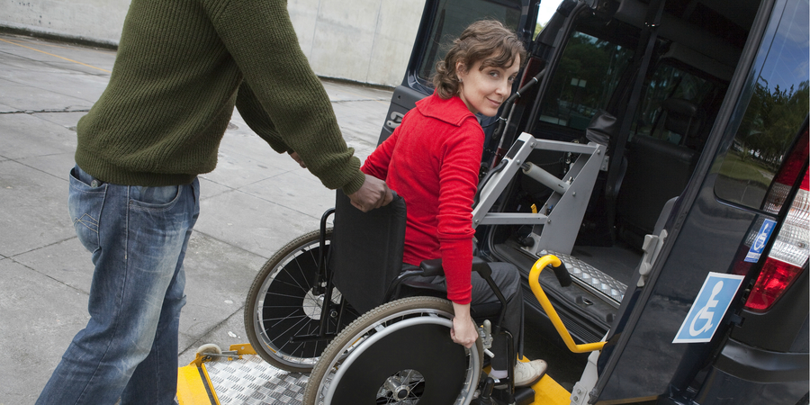 Vrouw in rolstoel neemt taxi.